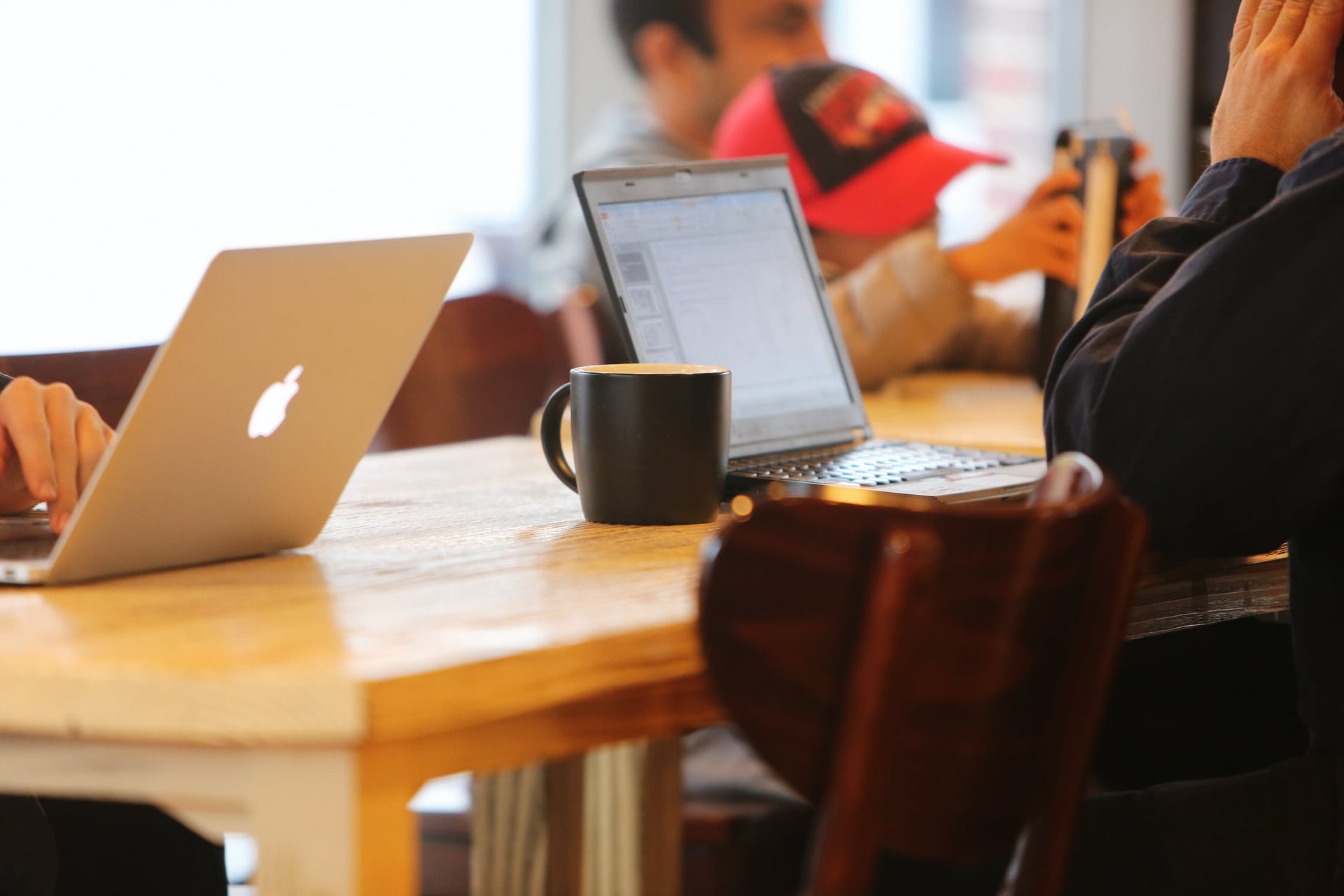image of people working on laptops around a table