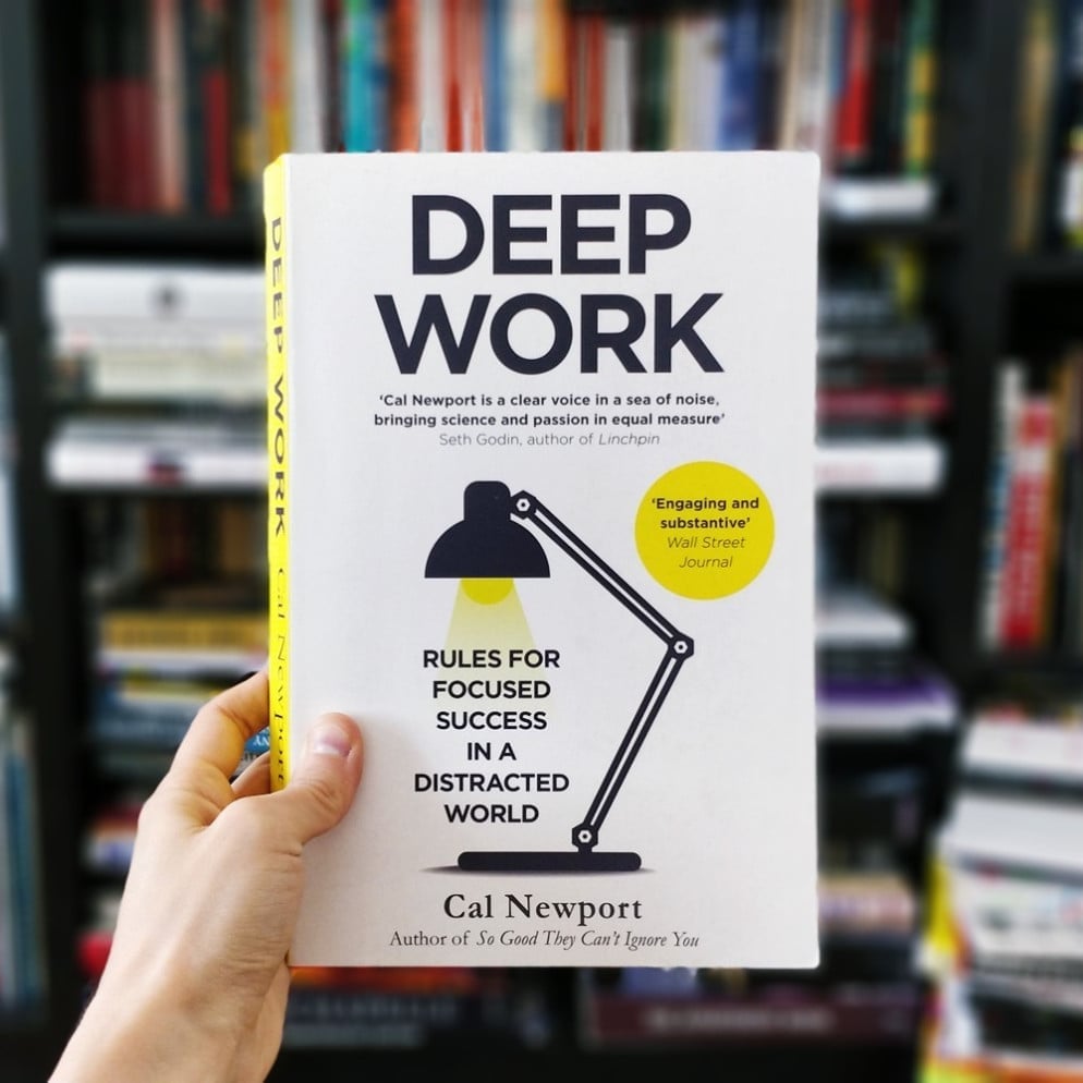 A mão segura o livro &quot;Deep Work&quot;, de Cal Newport