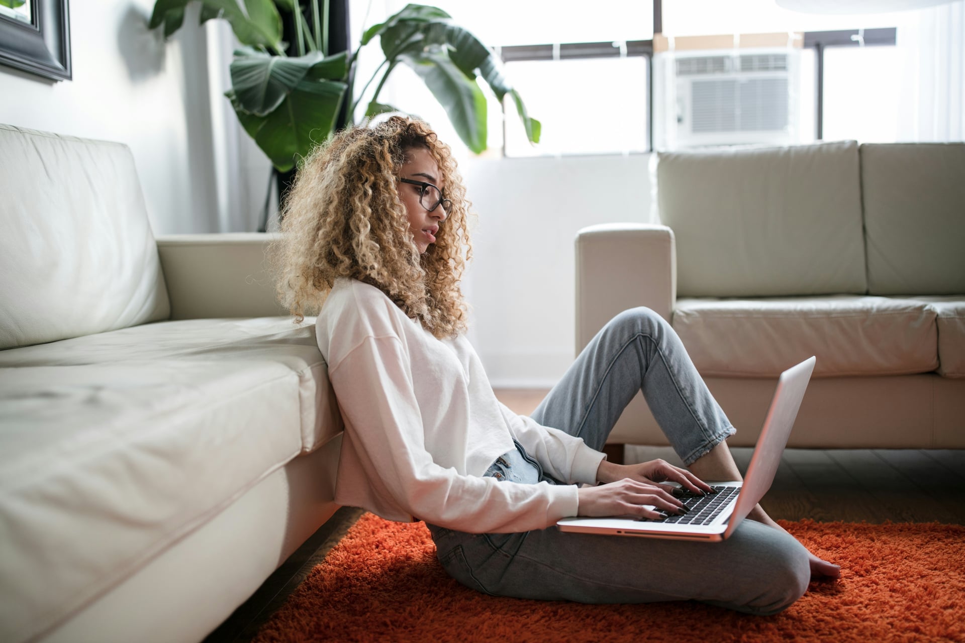 mulher sentada no chão com um laptop analisando um plano de melhoria de desempenho
